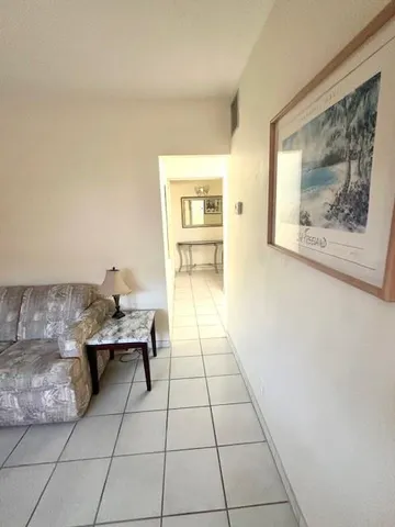 a living room with couches and large rug with wooden floor