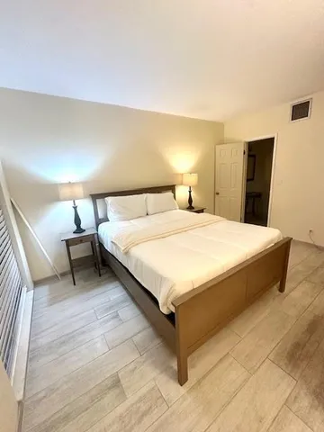 a bedroom with a bed and a night stand