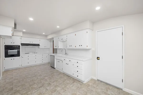 a large white kitchen with cabinets