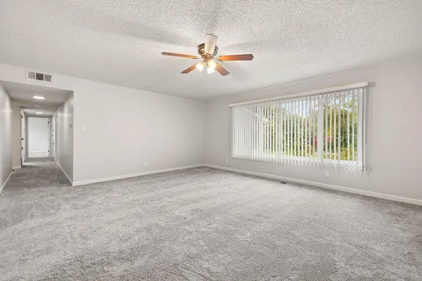 a view of a livingroom with a ceiling fan and window