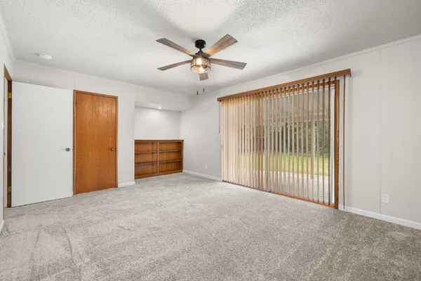 a view of a livingroom with a ceiling fan and window