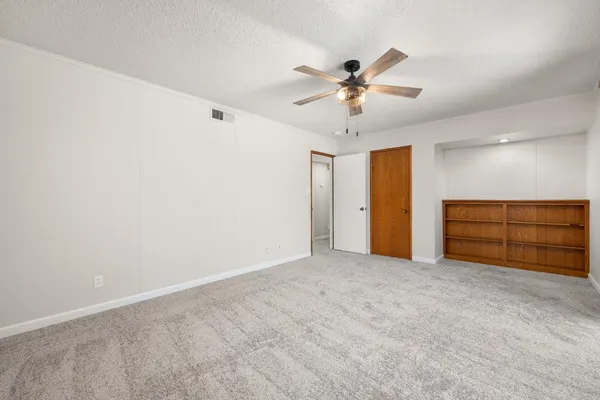 a view of an empty room with a ceiling fan