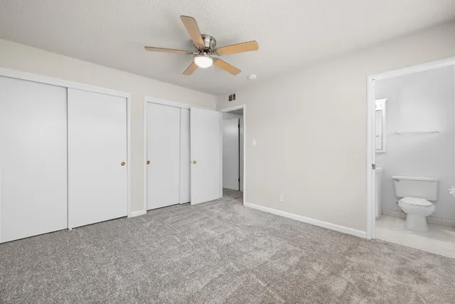 a view of a livingroom with a ceiling fan and a bathroom
