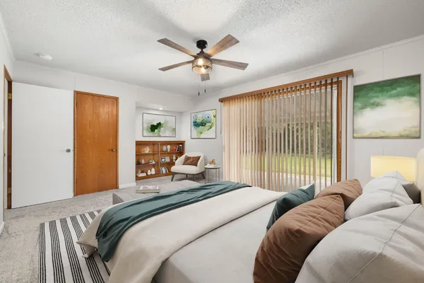 a bedroom with a bed and a large window