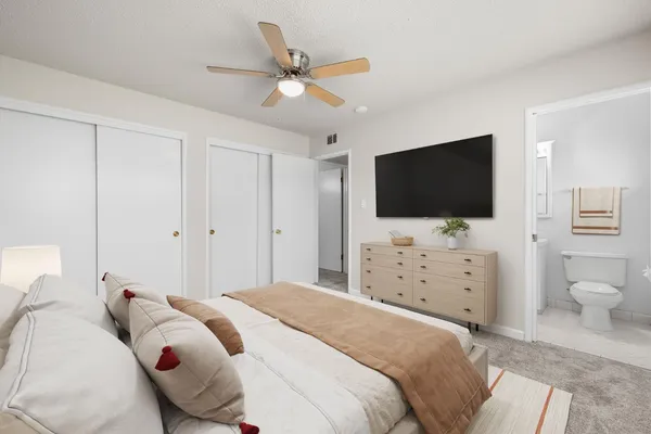 a bedroom with a bed tv and a flat screen tv