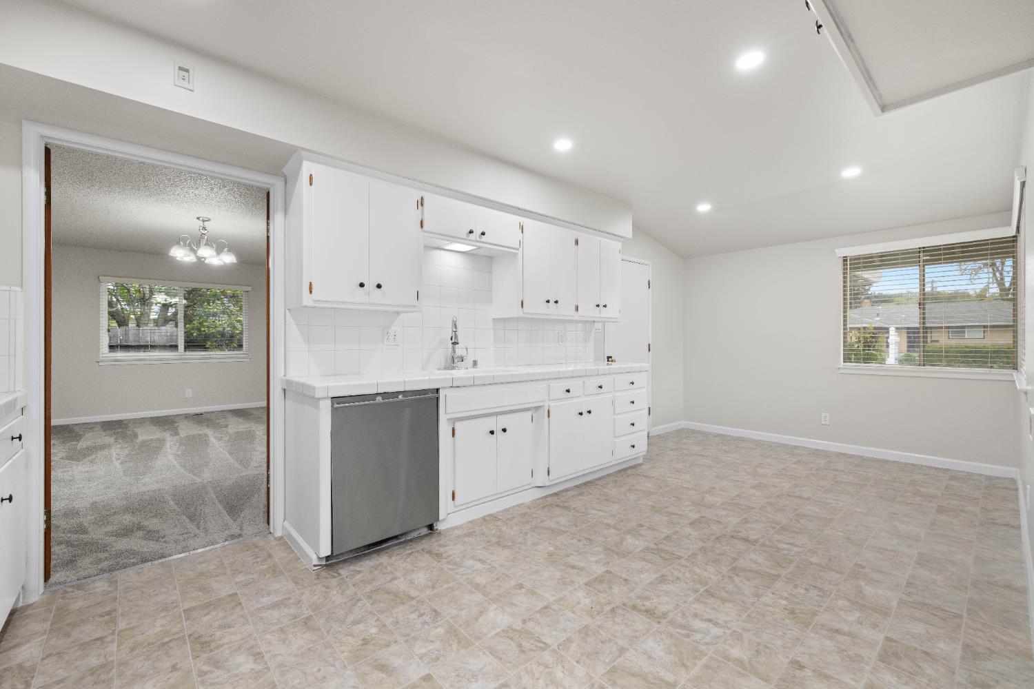 4907 Crestview Drive Carmichael, CA 95608 - Photo 9 of 33 a large white kitchen with kitchen island a sink stainless steel appliances and cabinets