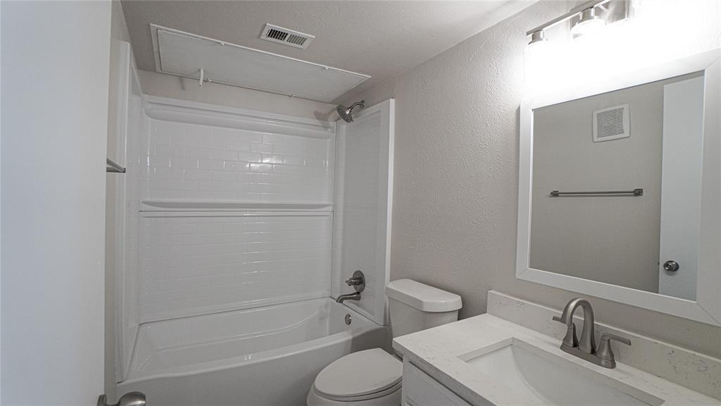4606 Chaha Road, Unit 103 Garland, TX 75043 - Photo 19 of 23 a bathroom with a granite countertop sink toilet and shower