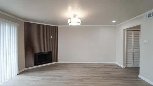an empty room with wooden floor cabinet and front door