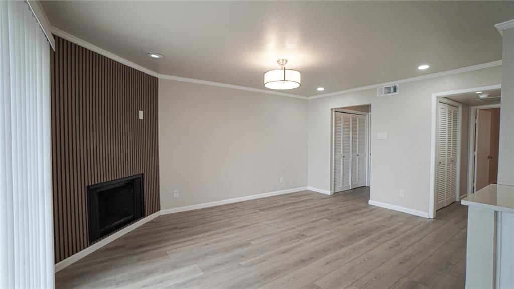 4606 Chaha Road, Unit 103 Garland, TX 75043 - Photo 4 of 23 an empty room with wooden floor fireplace and staircase