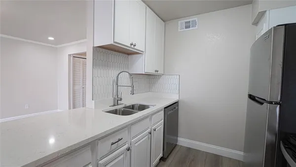 a kitchen with stainless steel appliances granite countertop a sink and a refrigerator