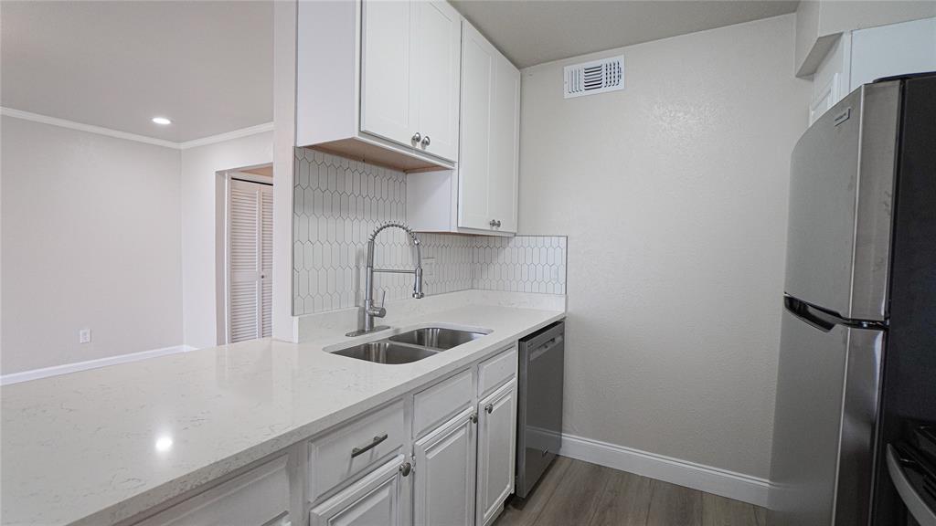 4606 Chaha Road, Unit 103 Garland, TX 75043 - Photo 10 of 23 a kitchen with stainless steel appliances granite countertop a sink and a refrigerator