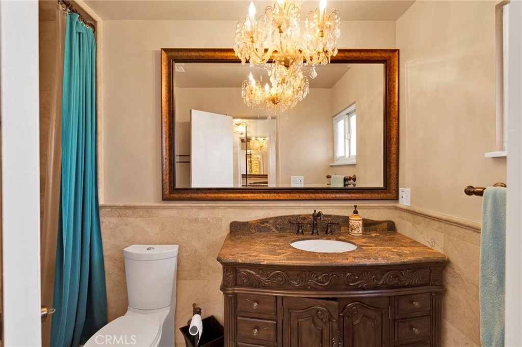 15177 Mendota Road North Apple Valley, CA 92307 - Photo 17 of 50 a bathroom with a granite countertop sink a toilet and a mirror