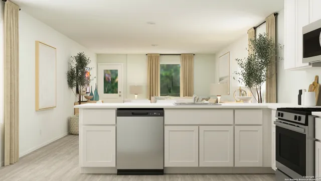 a kitchen with white cabinets and sink
