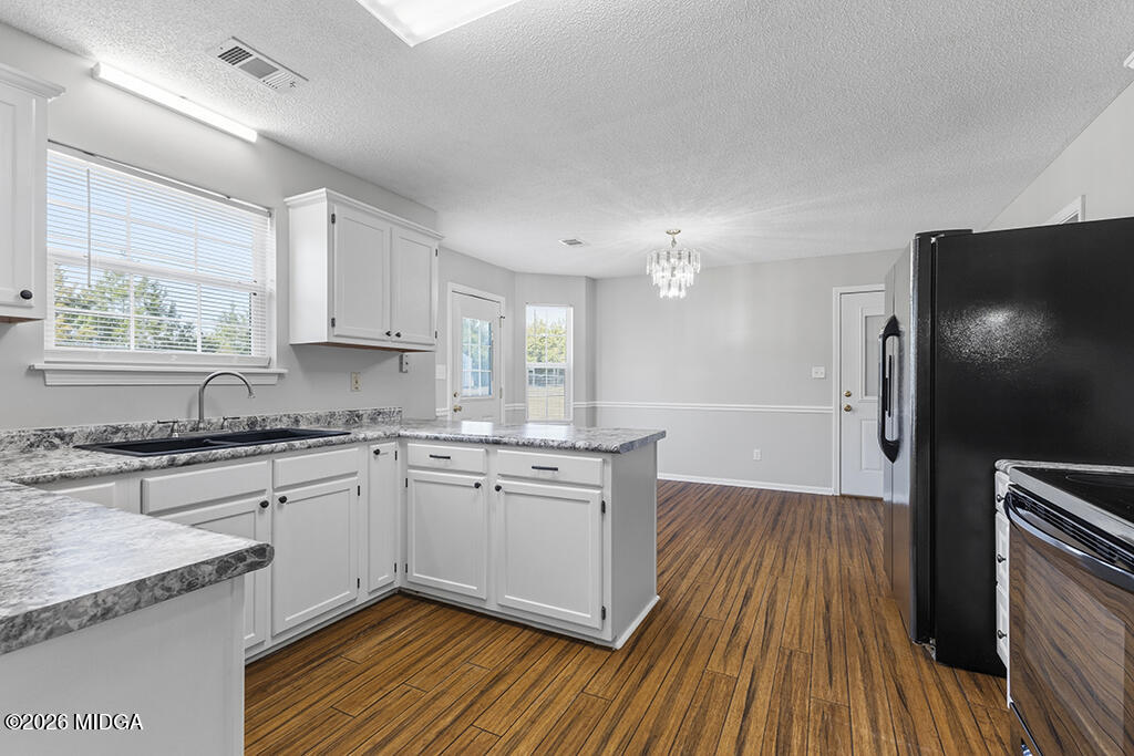 103 Echeconnee Ridge Road Warner Robins, GA 31093 - Photo 14 of 25 a kitchen with stainless steel appliances granite countertop hardwood floor sink stove and granite counter top