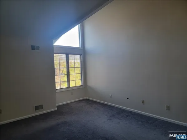an empty room with a fireplace and windows