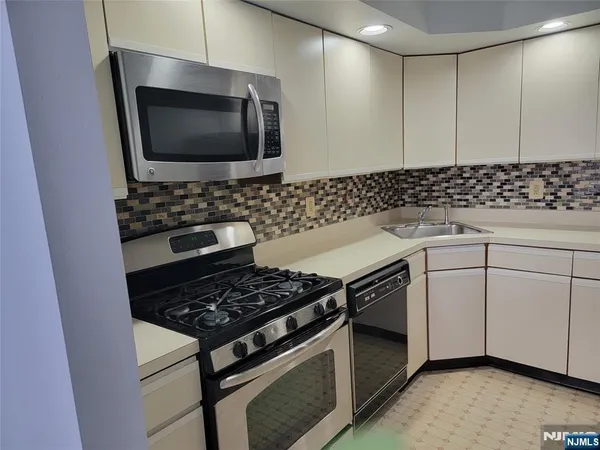 a kitchen with granite countertop a stove and a microwave