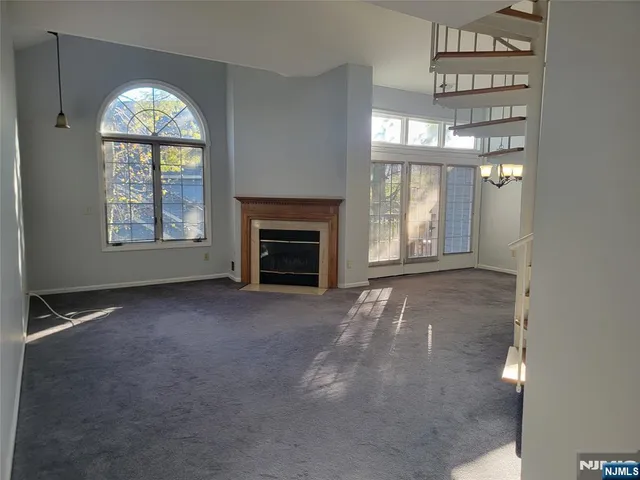 an empty room with a fireplace and windows