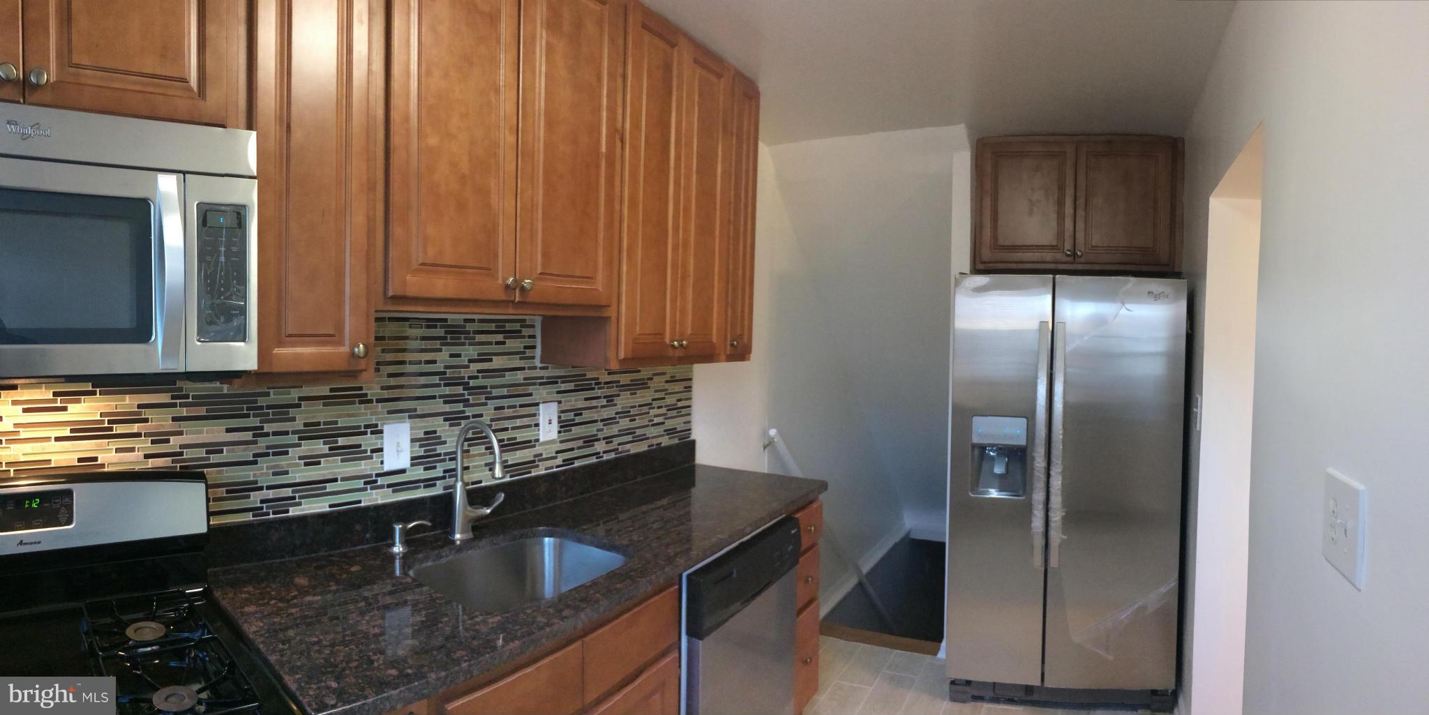 4415 Fenor Road Halethorpe, MD 21227 - Photo 13 of 29 a kitchen with granite countertop stainless steel appliances a sink stove refrigerator and cabinets