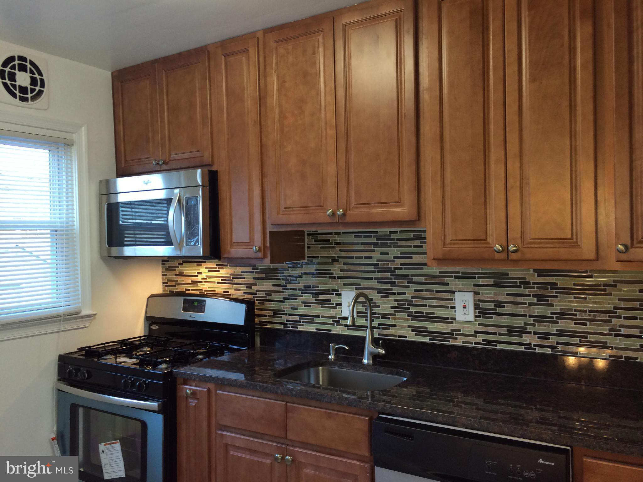 4415 Fenor Road Halethorpe, MD 21227 - Photo 14 of 29 a kitchen with granite countertop wood cabinets stainless steel appliances and a sink
