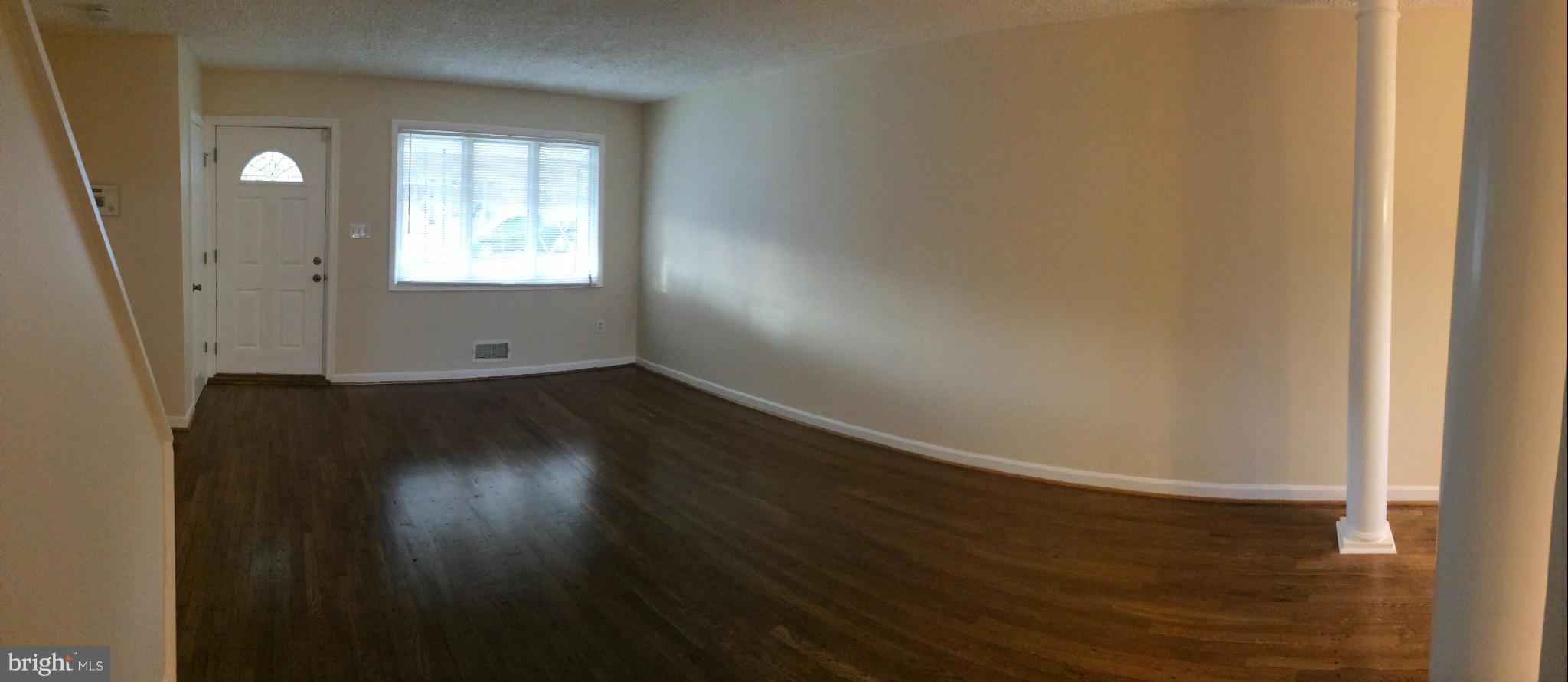 4415 Fenor Road Halethorpe, MD 21227 - Photo 7 of 29 an empty room with wooden floor and windows
