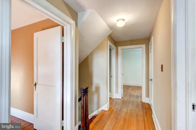 a view of a hallway with wooden floor and staircase
