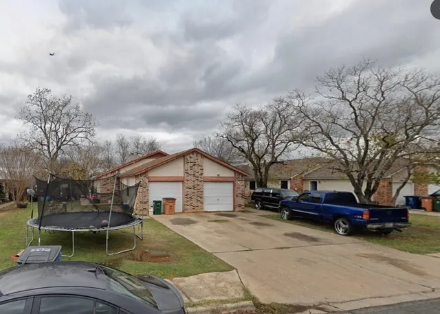 a view of a white house with a yard and garage