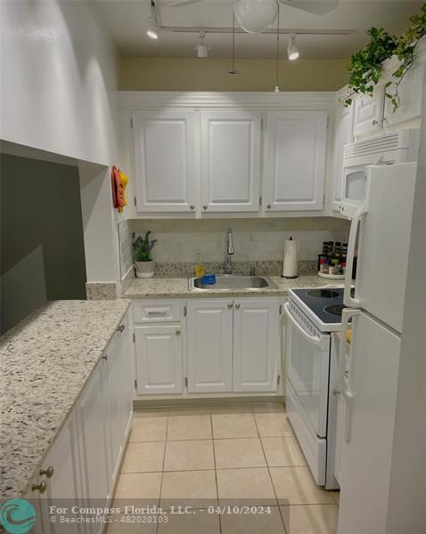 a kitchen with a sink a refrigerator and cabinets