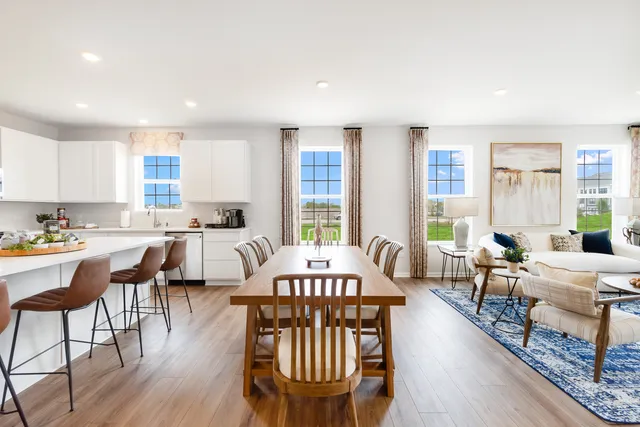 a view of a a dining room with furniture window and wooden floor