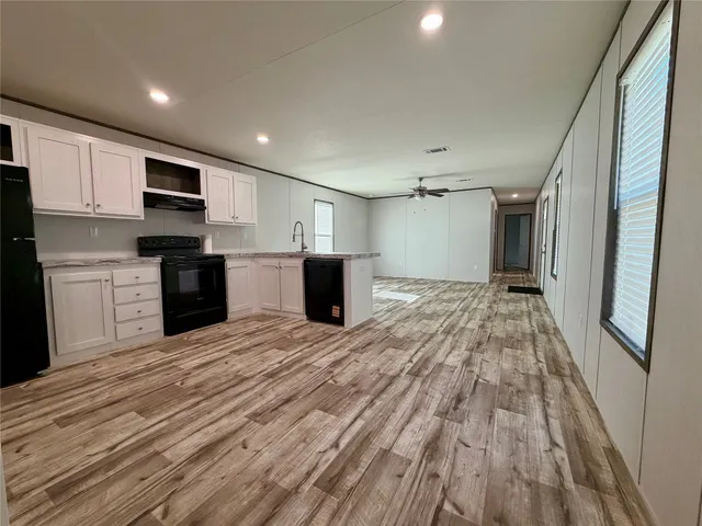 a view of kitchen with granite countertop cabinets and refrigerator