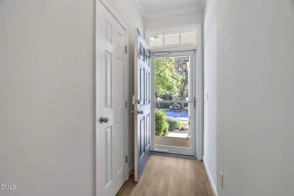 a view of a hallway with wooden floor and a window