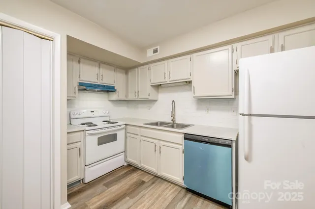 a kitchen with a sink cabinets stainless steel appliances and a window