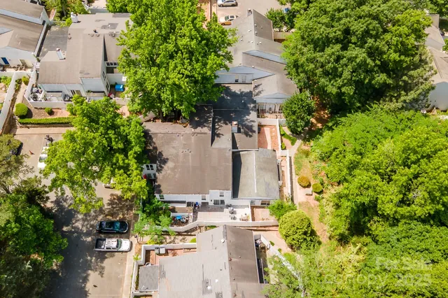 an aerial view of residential houses with outdoor space and trees