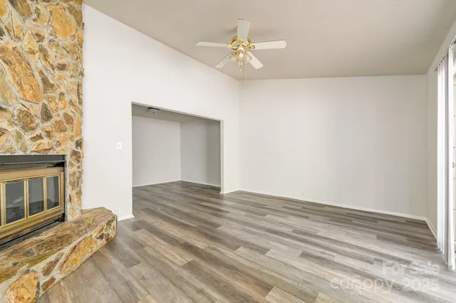 a view of a room with wooden floor and a ceiling fan