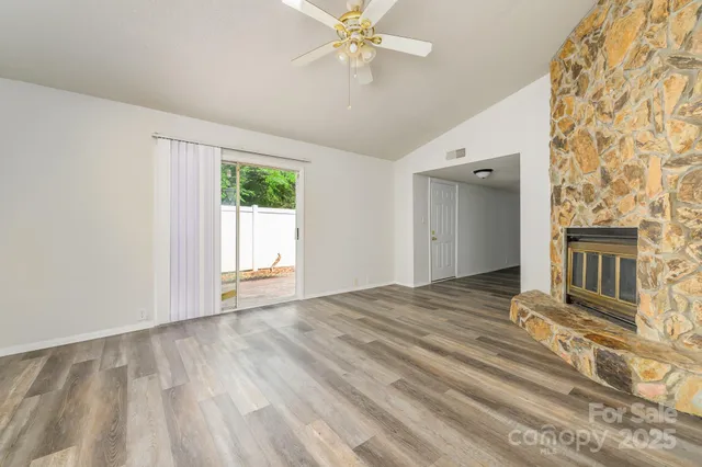 a view of a hallway with wooden floor and a living room