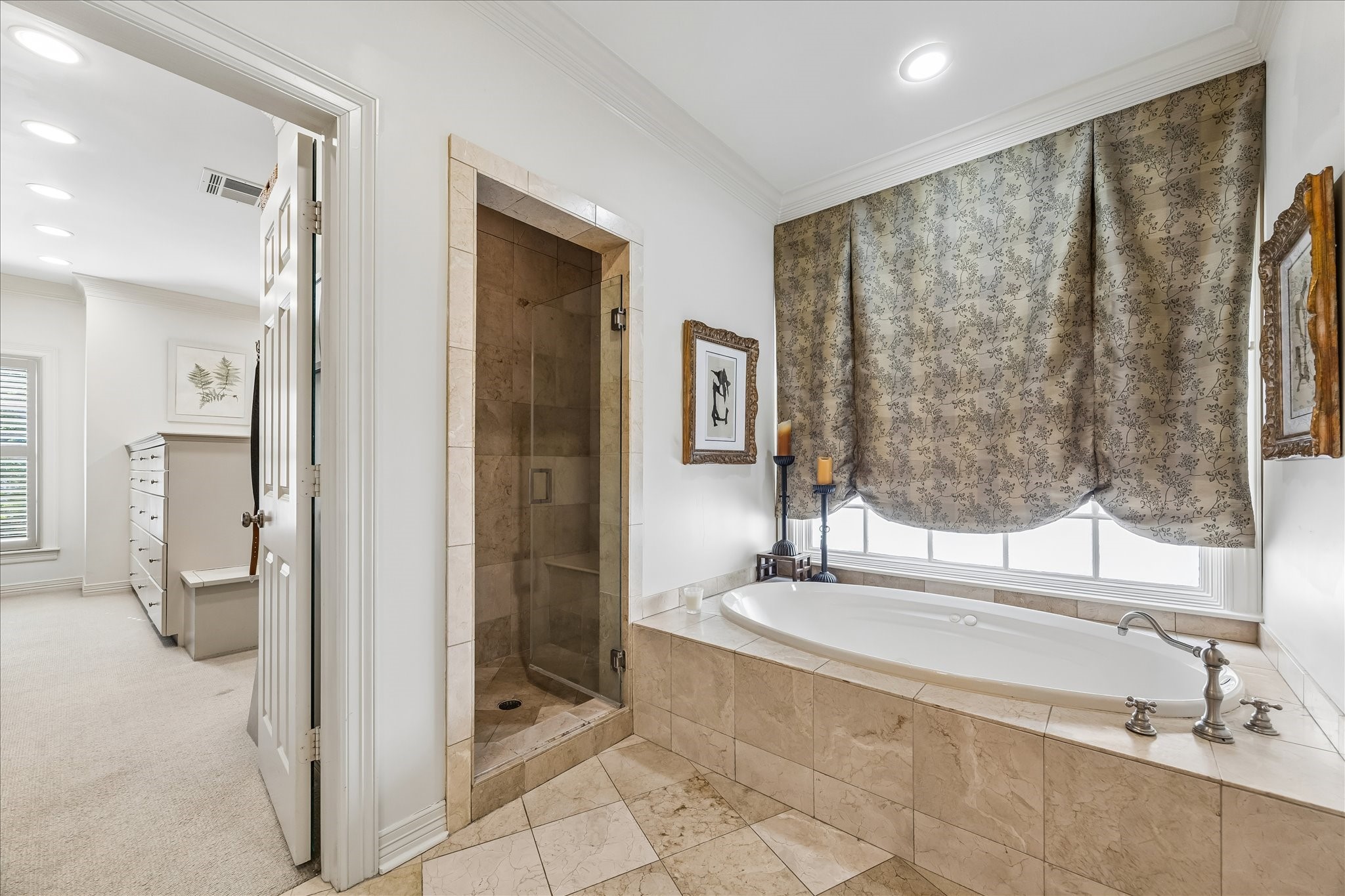 2627 Sutton Court Houston, TX 77027 - Photo 19 of 34 Custom drapery shades over the Jacuzzi tub make unwinding effortless. The photo also offers a sneak peek at the expansive walk-in closet, complete with a built-in dresser. You’ll love getting ready in this beautifully designed space!