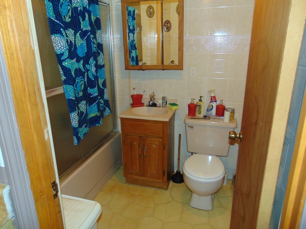 286 Riverside Drive Tiverton, RI 02878 - Photo 35 of 38 a bathroom with a toilet a sink and a shower curtain