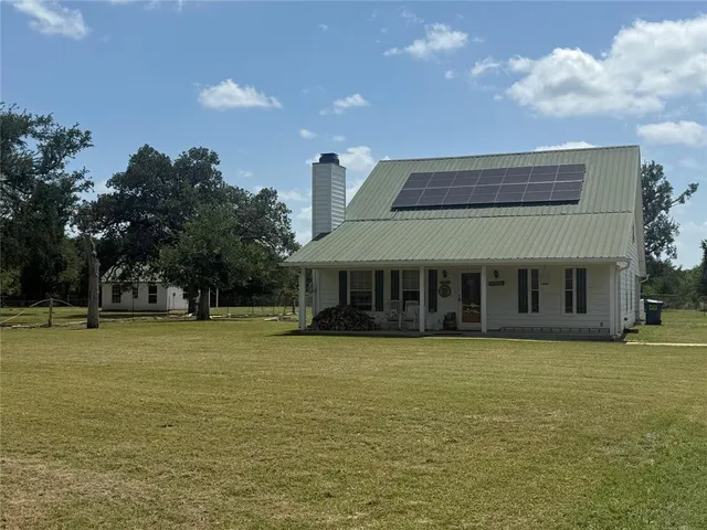 a view of a house with a swimming pool and a yard