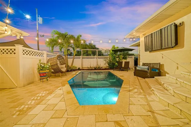 a view of a house with swimming pool and sitting area