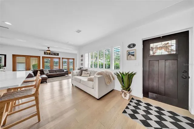 a living room with stainless steel appliances furniture and a kitchen view