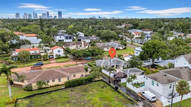 an aerial view of city and lake with trees