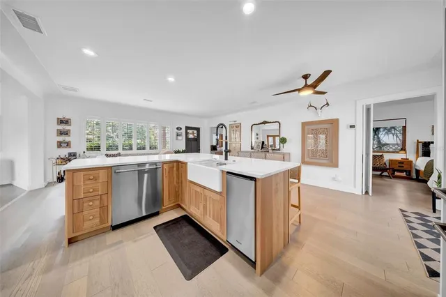 a large kitchen with stainless steel appliances a sink a stove and a refrigerator