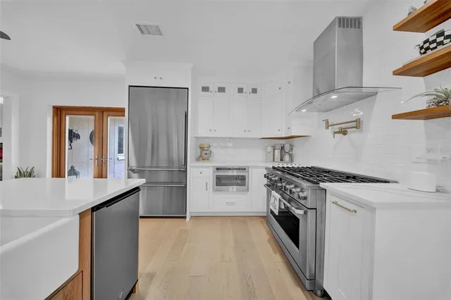 a kitchen with stainless steel appliances granite countertop a stove and a sink