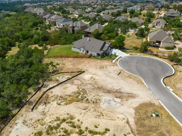 an aerial view of a house with a yard and lake view