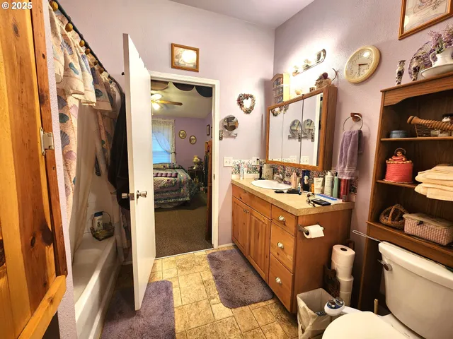 a bathroom with a sink a toilet a mirror and shower