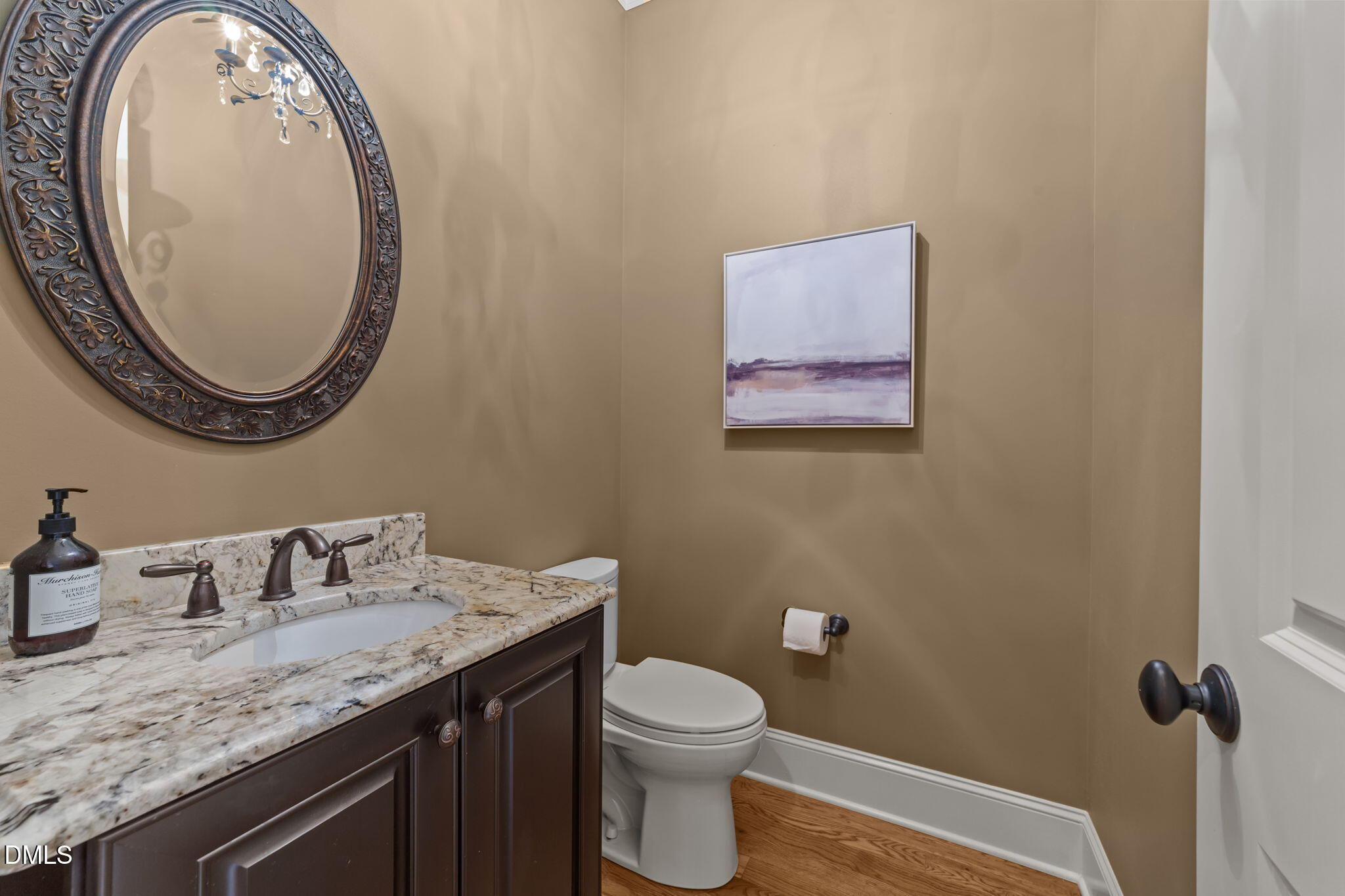 1859 Versa Court Apex, NC 27502 - Photo 24 of 46 a bathroom with a granite countertop toilet a sink and a mirror
