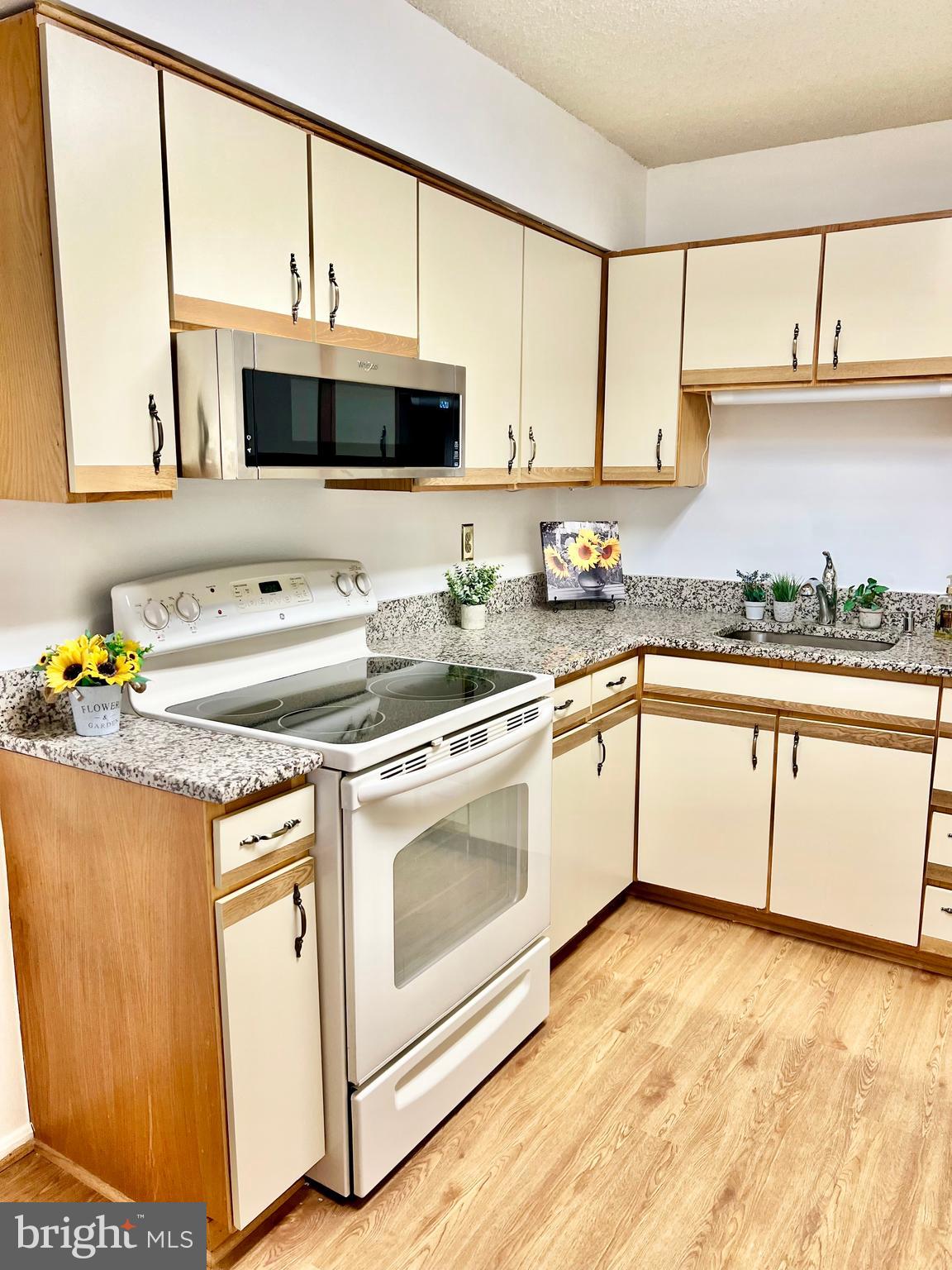15115 Interlachen Drive, Unit 3603 Silver Spring, MD 20906 - Photo 16 of 49 a kitchen with stainless steel appliances granite countertop a stove a sink and a microwave