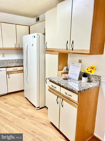 a kitchen with granite countertop a refrigerator and a sink