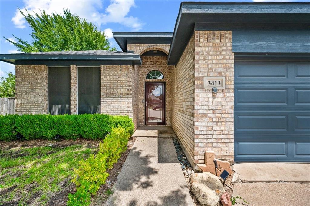 3413 Westfork Ranch Road Fort Worth, TX 76262 - Photo 3 of 35 Brick exterior featuring a paneled garage door and arched entry