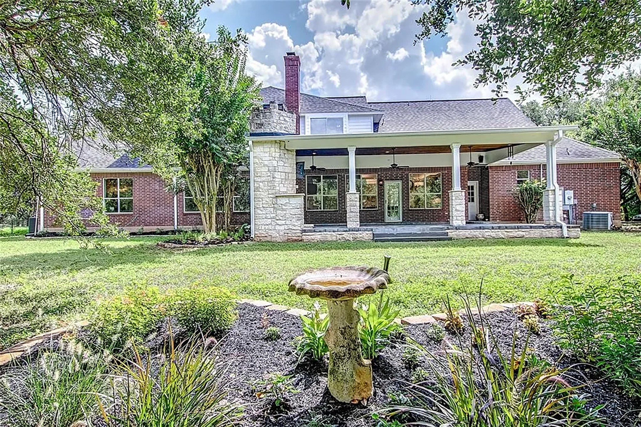 front view of a brick house with a yard