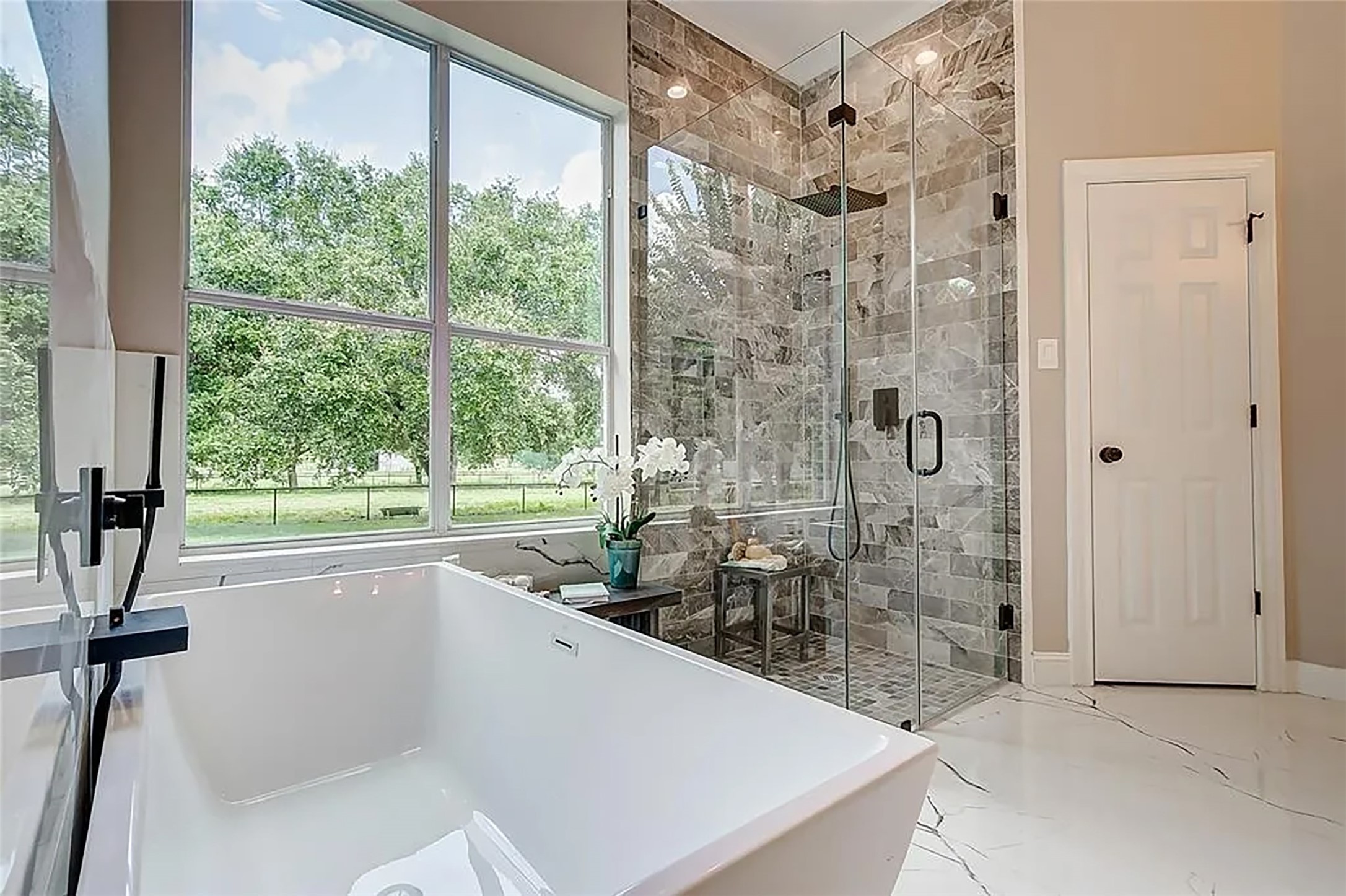 4421 Bowser Road Fulshear, TX 77441 - Photo 16 of 41 a bathroom with a granite countertop sink a large mirror and a bathtub